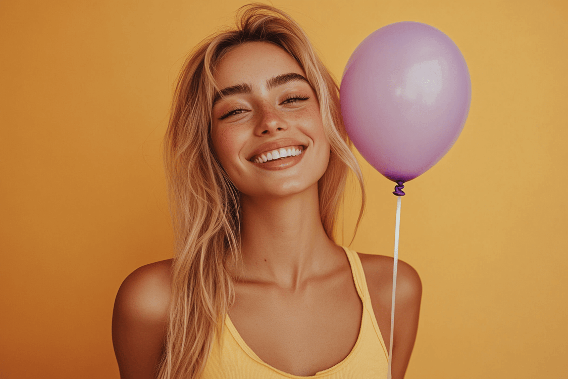 jovem loira e sorrindo com bexiga na mão