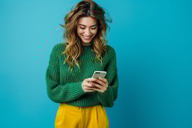 menina com celular na mão e sorrindo