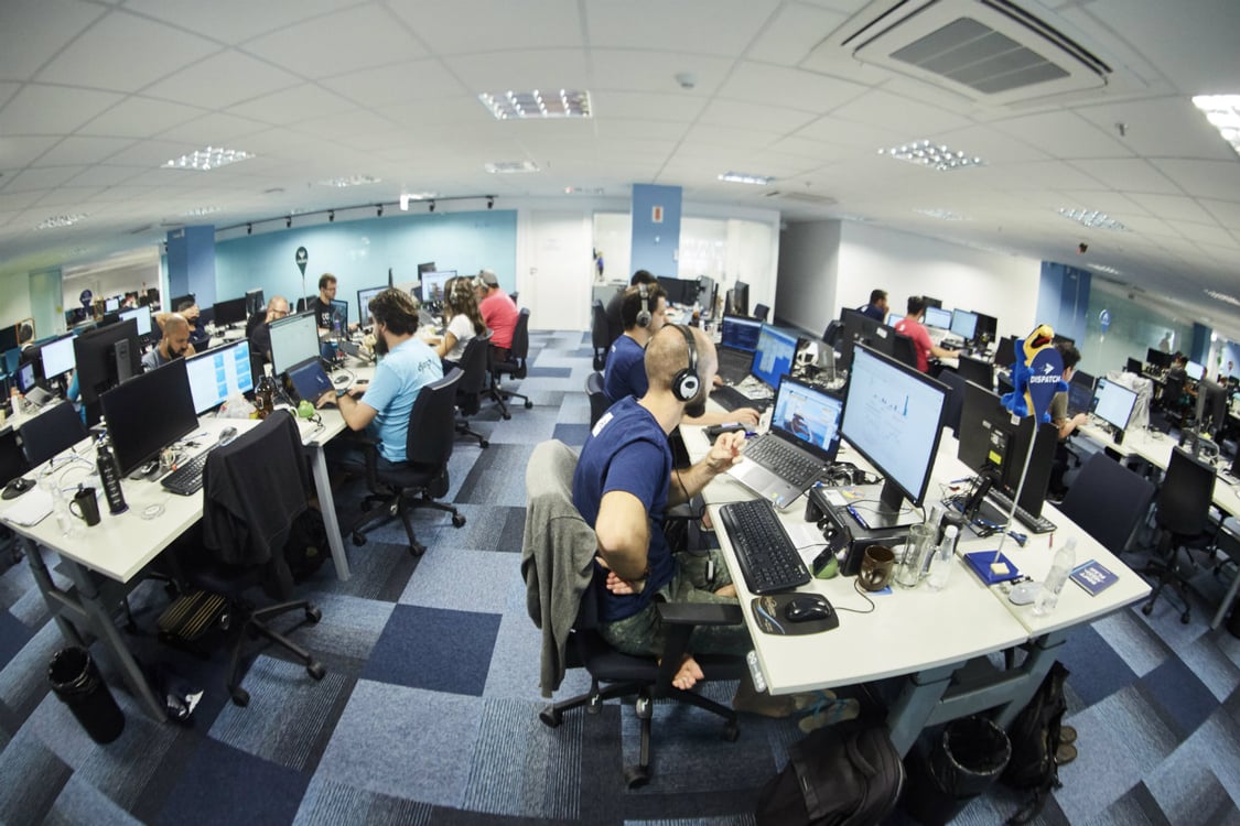 escritório cheio de pessoas trabalhando em suas mesas