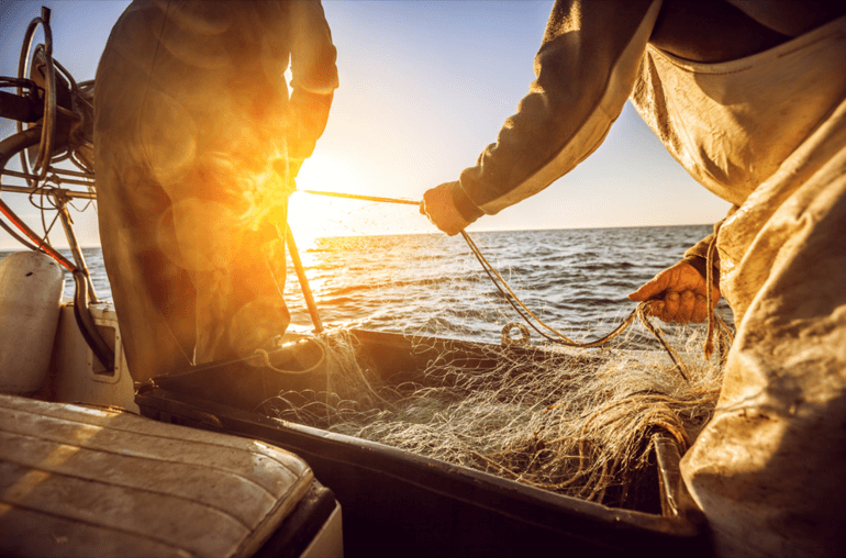 homens no barco pescando peixes